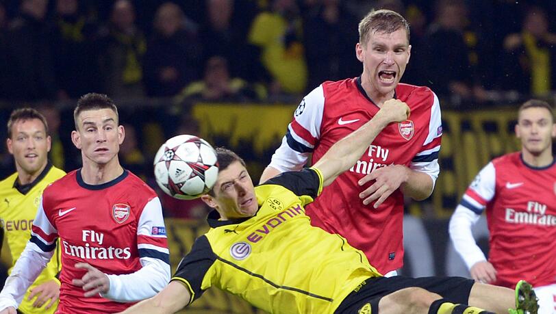Dortmunds Robert Lewandowski (vorn) kämpft gegen Arsenals Per Mertesacker (M) und Laurent Koscielny (l) um den Ball.