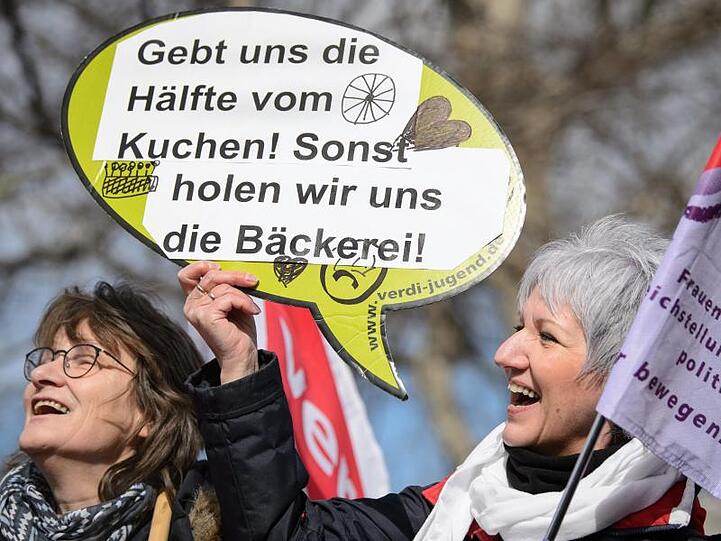 Das ist doch mal ein Argument: Frauen demonstrieren am Internationalen Frauentag mit einem Plakat für gleiche Rechte und gleiche Entlohnung.