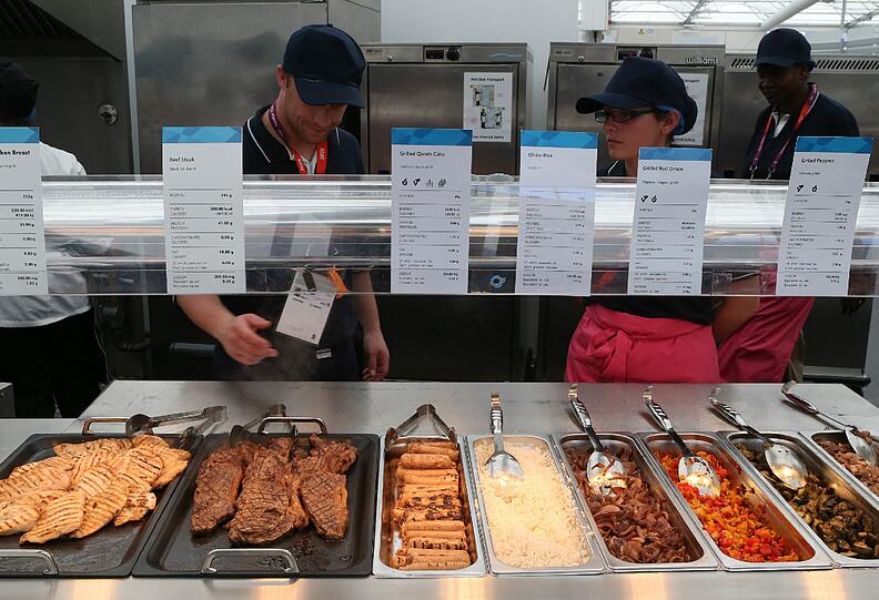 Kochbücher und Campingkocher konnten die 10.500 Athleten aus aller Welt daheim lassen. In der Olympia-Mensa gibt es zwar auch britische Kost, aber eben auch alles, was das Herz begehrt: koscheres Essen, solches ohne Schweinefleisch, für militante Vegetarier ist ebenso gesorgt wie für Karibik-, Indien- und Thaifans. Es gibt sogar die gute deutsche Bratwurst. Nur auf die Maß Bier müssen die Olympioniken verzichten. Im gigantischen Gourmettempel und drumherum wird kein Alkohol ausgegeben.