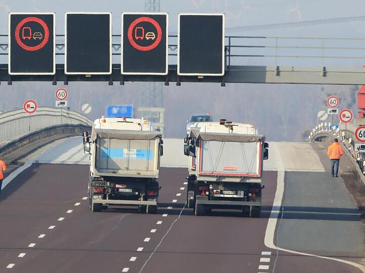 Vier LKW fahren über die Elbbrücke der Autobahn 2 bei Lostau.