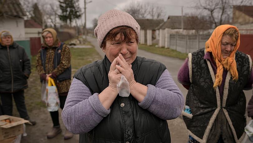 Eine weinende Frau in Motyschyn wartet zusammen mit anderen Dorfbewohnern auf die Verteilung von Lebensmitteln, das bis vor kurzem unter der Kontrolle des russischen Militärs stand. Eine weinende Frau in Motyschyn wartet zusammen mit anderen Dorfbewohnern auf die Verteilung von Lebensmitteln, das bis vor kurzem unter der Kontrolle des russischen Militärs stand.