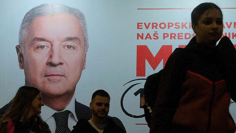 Der Wahlkampf ist zu Ende: Menschen gehen an einem Plakat des pro-westlichen Amtsinhabers Milo Djukanovic vorbei.
