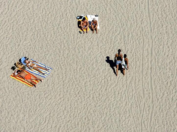Urlauber genießen am Strand von Travemünde an der Ostsee die Sonne.