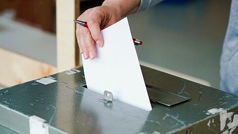 Ein Wählerin wirft in einem Wahllokal ihren Stimmzettel in die Wahlurne.