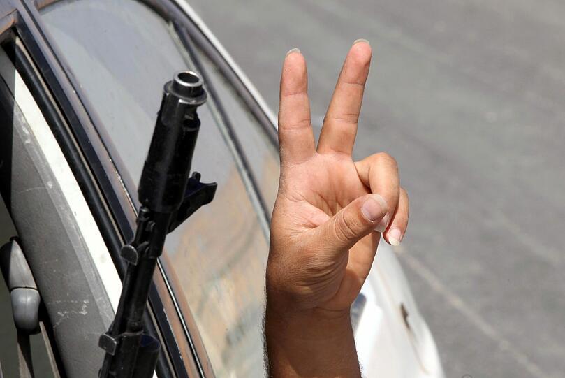 Hier feiern die Rebellen die Eroberung der Stadt Bani Walid, einem Vorort der bis zuletzt heftig umkämpften Geburtsstadt Gaddafis, Sirte. Das "Victory"-Zeichen ("Sieg") wird zum allgegenwärtigen Symbol der Befreieung Libyens.  So auch...