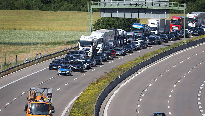 Autos stauen sich hinter einem Polizeiauto auf der A8 vor der Anschlussstelle Günzburg.
