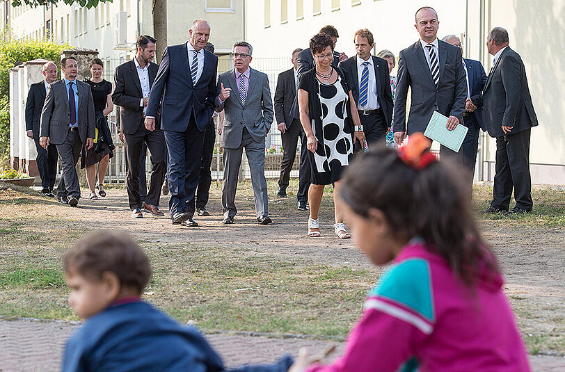 Thomas de Maiziere (M) beim Besuch der Erstaufnahmestelle in Eisenhüttenstadt.