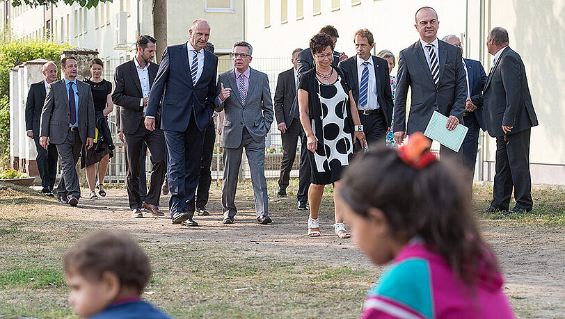 Thomas de Maiziere (M) beim Besuch der Erstaufnahmestelle in Eisenhüttenstadt.