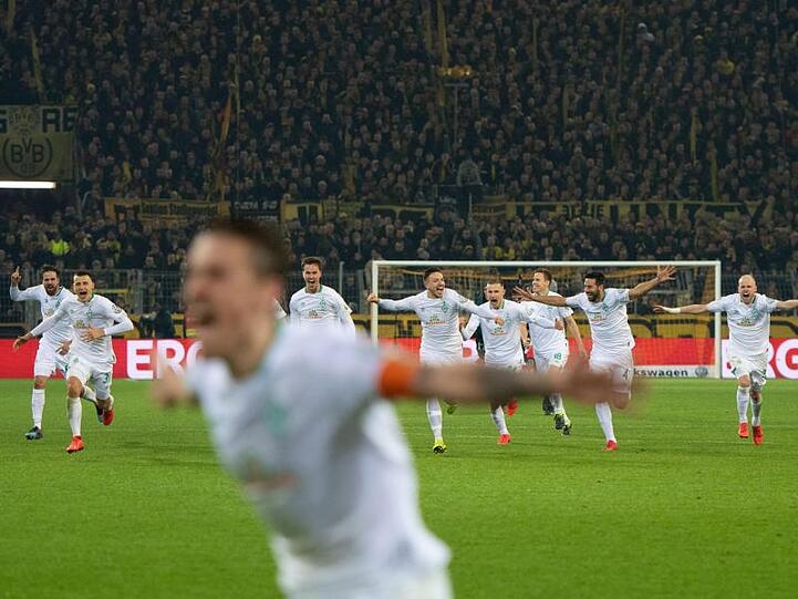 Nach dem entscheidenden Treffer im Elfmeterschießen laufen die Spieler von Werder Bremen auf den Torschützen Max Kruse (vorn) zu.