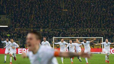 Nach dem entscheidenden Treffer im Elfmeterschießen laufen die Spieler von Werder Bremen auf den Torschützen Max Kruse (vorn) zu.