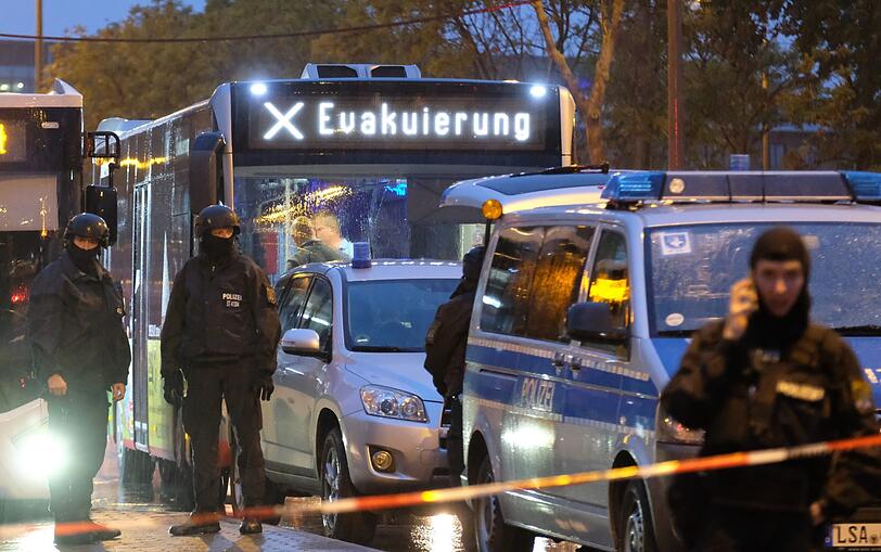 Ein Bus mit der Aufschrift "Evakuierung" wird von Polizeikräften eskortiert.
