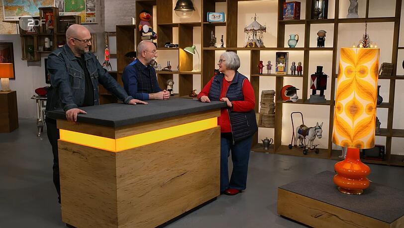 "Die 70er leben wieder!", jubelte "Bares für Rares"-Moderator Horst Lichter (Mitte), als er die Leuchte erblickte. "Die 70er leben wieder!", jubelte "Bares für Rares"-Moderator Horst Lichter (Mitte), als er die Leuchte erblickte.