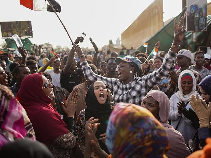 Sudanesische Demonstranten feiern die Verhaftung des langjährigen Präsidenten Omar al-Bashir durch die Streitkräfte außerhalb des Verteidigungsministeriums.