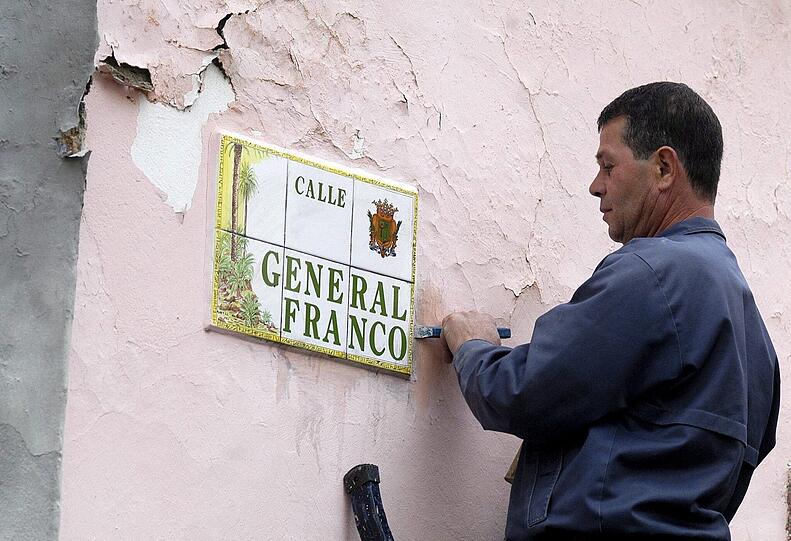 Ein Arbeiter entfernt ein Straßenschild mit Francos Namen auf Gran Canaria.