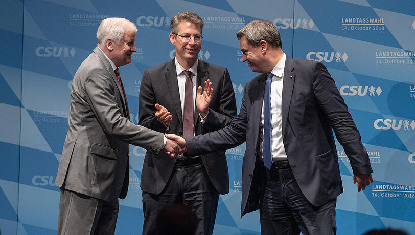 Seehofer (l) und Söder reichen sich die Hand, Generalsekretär Markus Blume applaudiert. Seehofer (l) und Söder reichen sich die Hand, Generalsekretär Markus Blume applaudiert.