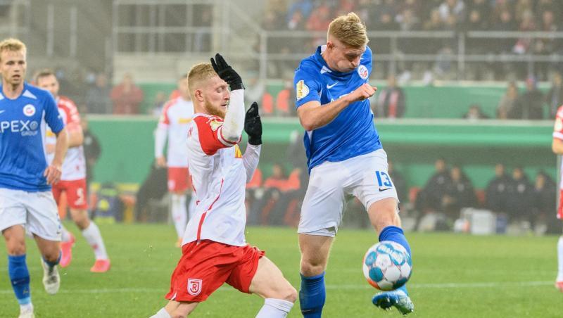 Regensburg Jan-Niklas Beste (l) und Kevin Schumacher von Hansa Rostock im Zweikampf um den Ball.