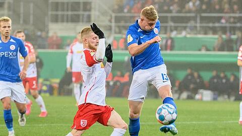 Regensburg Jan-Niklas Beste (l) und Kevin Schumacher von Hansa Rostock im Zweikampf um den Ball.