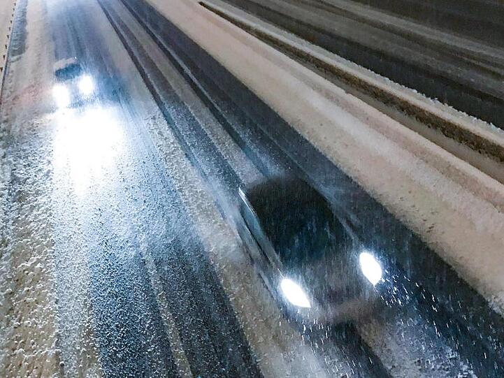 Autos fahren über die schneebedeckte Autobahn bei Saint-Etienne.