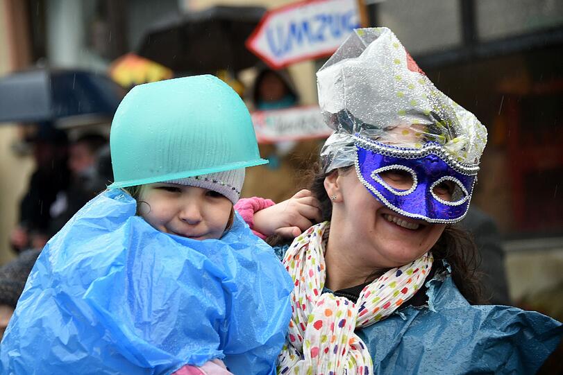 Gut behütet: Frau und Kind trotzen beim traditionellen Springerzug in Herbstein/Hessen dem Regen.