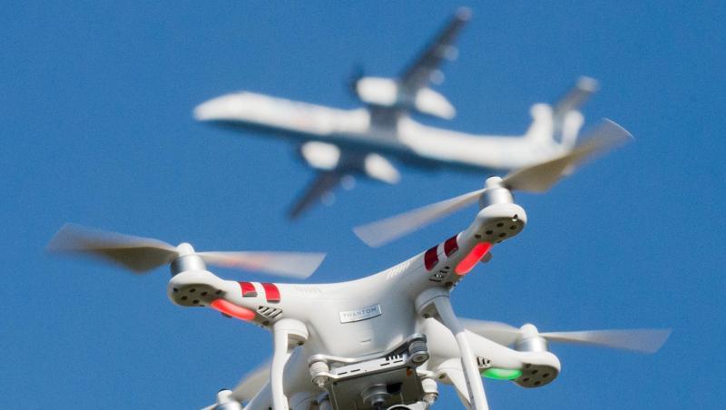 Eine private Drohne fliegt in knapp 10 Metern Flughöhe über einem Garten, in weiter Entfernung ist ein Flugzeug beim Anflug auf den Flughafen Düsseldorf zu sehen ist. Eine private Drohne fliegt in knapp 10 Metern Flughöhe über einem Garten, in weiter Entfernung ist ein Flugzeug beim Anflug auf den Flughafen Düsseldorf zu sehen ist.