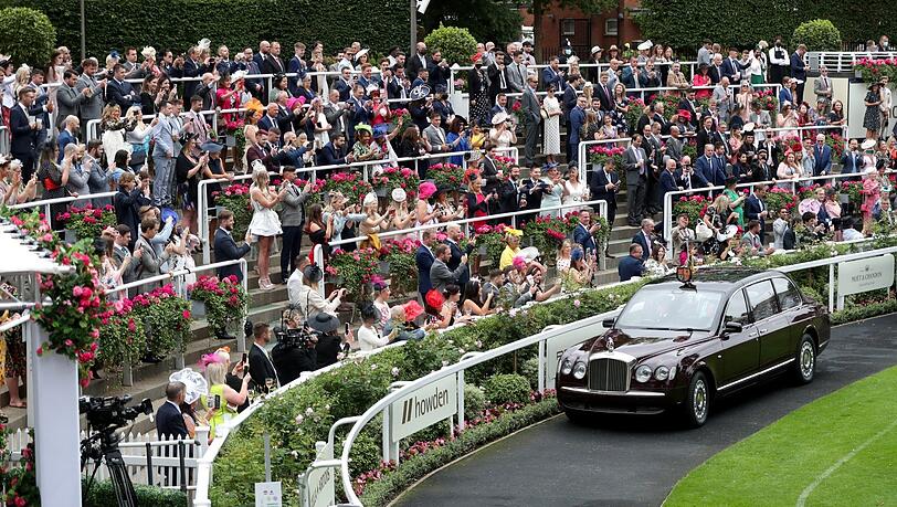 Hier kommt die Königin: Die Besucher jubeln auf der Tribüne, während Elizabeth II. am fünften Tag des Royal Ascot mit dem Auto ankommt. Hier kommt die Königin: Die Besucher jubeln auf der Tribüne, während Elizabeth II. am fünften Tag des Royal Ascot mit dem Auto ankommt.