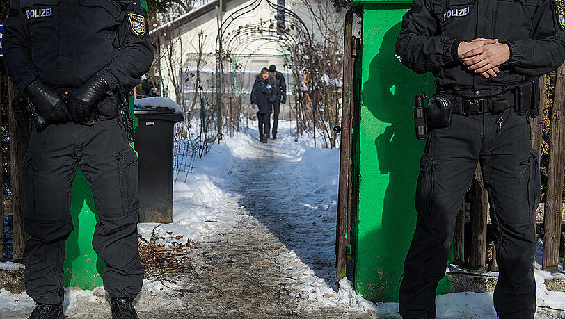 Polizisten stehen vor dem Haus, in dem sich die schreckliche Tat ereignete. Polizisten stehen vor dem Haus, in dem sich die schreckliche Tat ereignete.