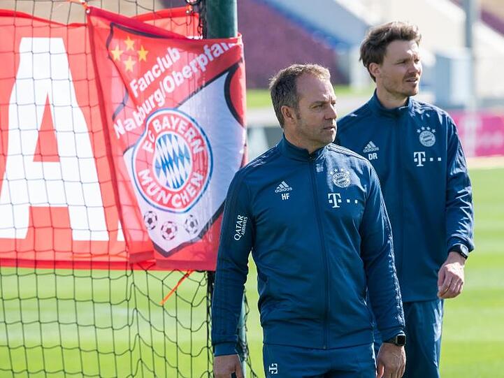 Trainer Hansi Flick (l) und Co-Trainer Danny Röhl gehen bei einer Übungseinheit am Vormittag über das Trainingsgelände.