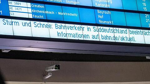 "Sturm und Schnee: Bahnverkehr in Süddeutschland beeinträchtigt" steht auf einer Anzeigetafel. Foto: Daniel Karmann/dpa