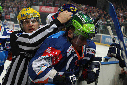 Banden-Gerangel: Tiger Björn Barta (rechts) bedrängt vom Linienrichter und Mannheims Felix Petermann (verdeckt).