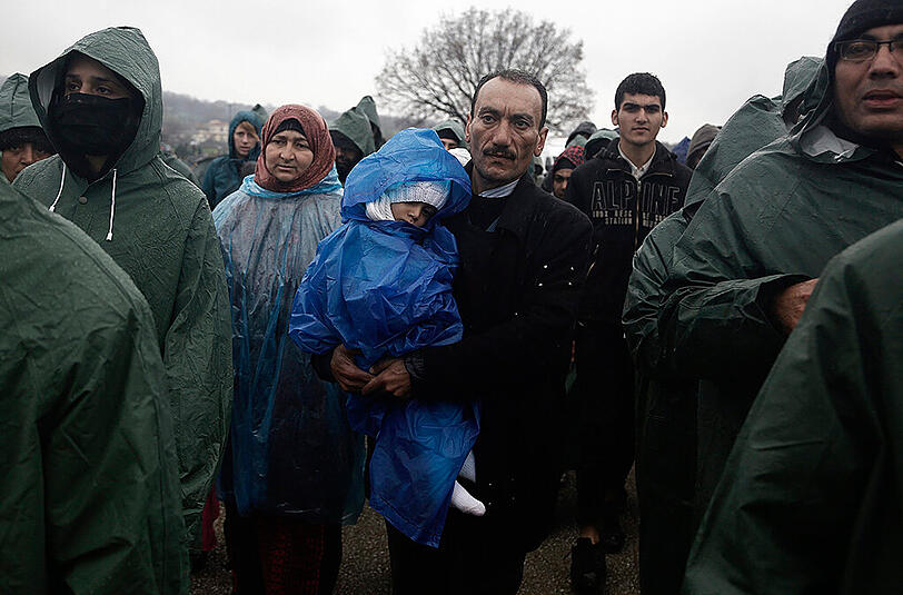 Hunderte Flüchtlinge aus dem Lager in Idomeni durchqueren einen reißenden Fluss auf griechischer Seite, um illegal nach Mazedonien zu gelangen.