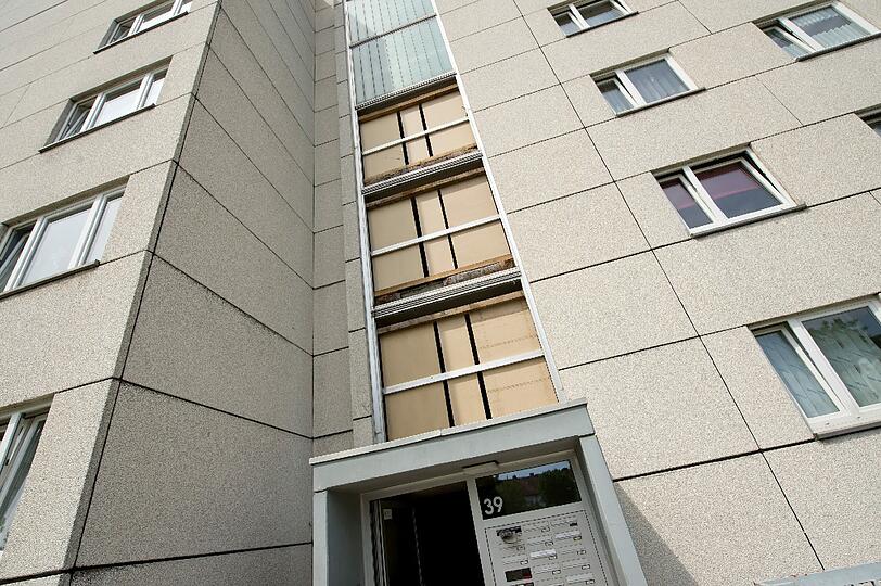 Die durch eine Explosion zerstörte Fassade des Treppenhauses ist am Montag in Garching bei München provisorisch mit Holz verkleidet. Aus unbekannten Gründen ist die Glasfassade eines Treppenhauses am 24.05.2014 geborsten. Ein Mann wurde dabei verletzt.