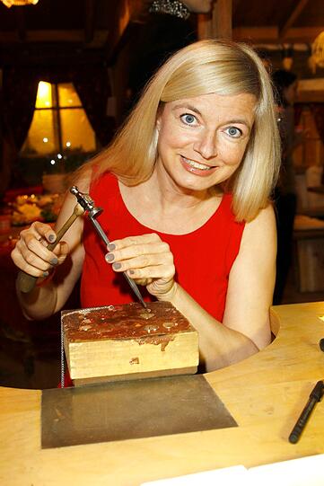 Schauspielerin und Sängerin Michaela Merten versucht sich als Holz-Künstlerin mit Hämmerchen und Meißel.