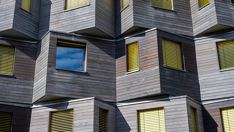 Moderne Münchner Mehrfamilienhäuser wie dieses mit Holzfassade bräuchte die Stadt. Doch kaum einer traut sich noch, neu zu bauen, wegen enormer Baukosten.