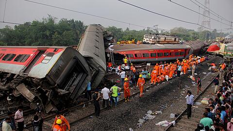 Rettungskräfte arbeiten an der Unfallstelle nach dem schweren Zugunglück im indischen Bundesstaat Odisha.