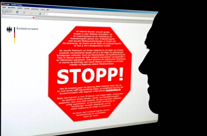 Ein Mann schaut am Computer auf eine Seite des Bundeskrimalamtes, auf der ein Stoppschild für eine Internetseite mit kinderpornografischen Inhalten zu sehen ist.