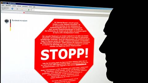 Ein Mann schaut am Computer auf eine Seite des Bundeskrimalamtes, auf der ein Stoppschild für eine Internetseite mit kinderpornografischen Inhalten zu sehen ist.
