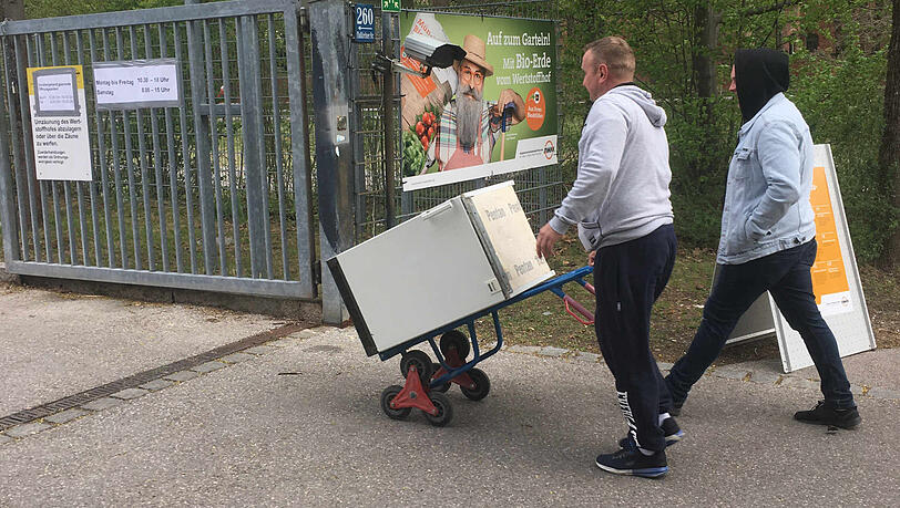 Zwei Männer fahren einen alten Kühlschrank zum Wertstoffhof. Zwei Männer fahren einen alten Kühlschrank zum Wertstoffhof.