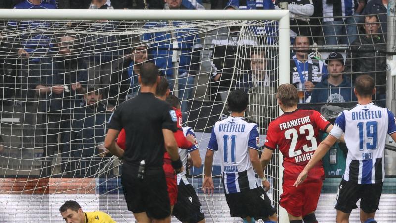 Bielefelds Torwart Stefan Ortega (l) kassiert den Gegentreffer zum 0:1 durch Frankfurts Jens Petter Hauge (2.v.r).