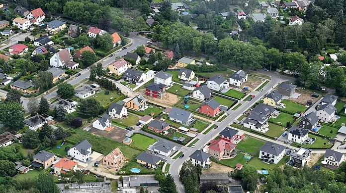 Grüner Rasen und Einfamilienhäuser bestimmen das Bild einer Stadtrandsiedlung.