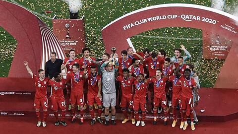 Die Spieler des FC Bayern München feiern mit der Trophäe.