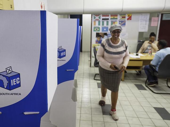 Eine Wahlhelferin geht in Johannesburg an Wahlkabinen vorbei.