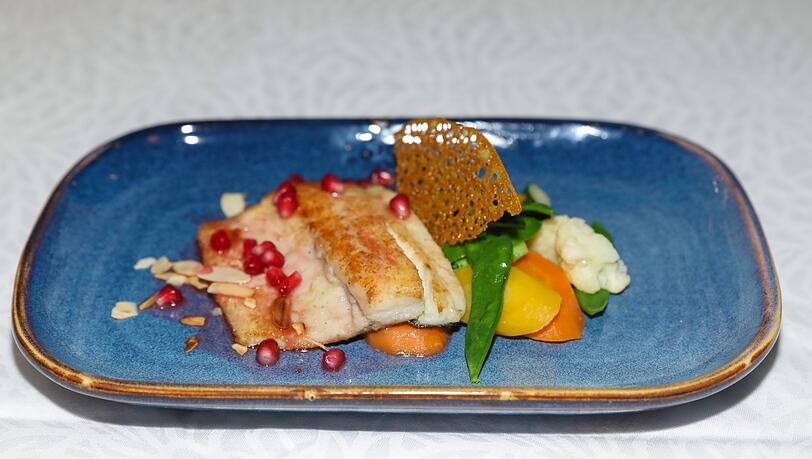 Dritter Gang: Wolfsbarschfilet mit Mandeln, Granatapfel und Saisongemüse. Dritter Gang: Wolfsbarschfilet mit Mandeln, Granatapfel und Saisongemüse.
