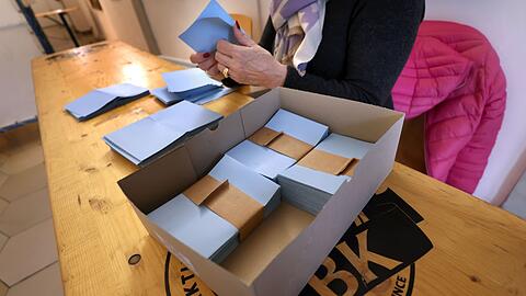 Eine Wahlhelferin sortiert bei der Stichwahl Stimmzettel.