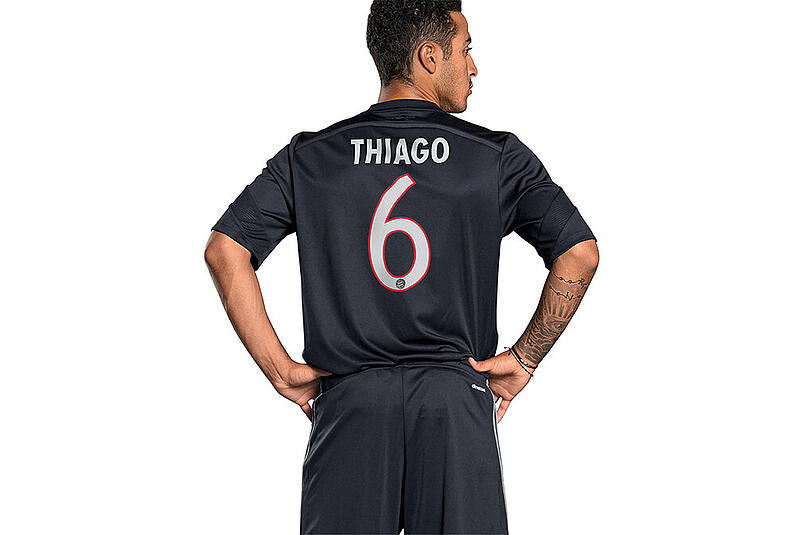 Für die Präsentation des neuen Gewands schlupft Thiago aber schon einmal rein. Auf der Vorderseite ein roter Längsstreifen, sonst ganz in schwarz präsentieren sich die Bayern in der Königsklasse.