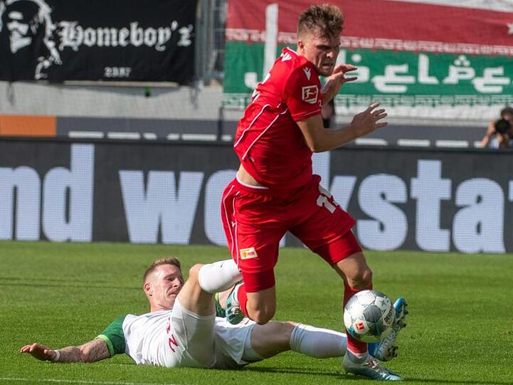 Augsburgs Andre Hahn (l) stoppt Berlins Marius Bülter mit unfairen Mitteln.