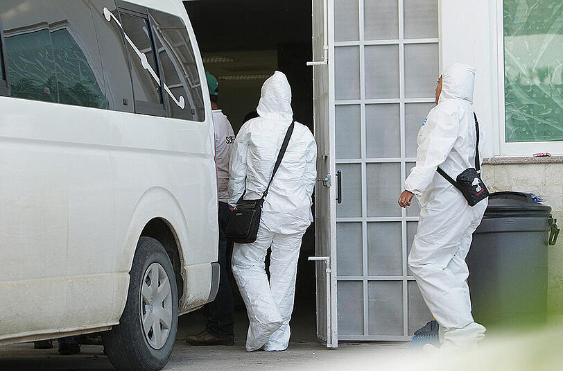 Forensiker betreten ihr Labor in Iguala. Dabei haben sie die Körperteile der in sechs Massengräbern gefundenen Studenten-Leichen.