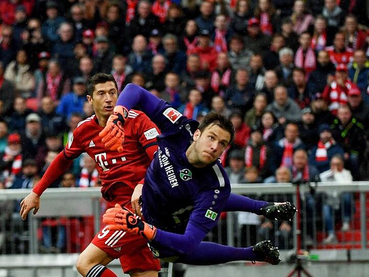 Münchens Robert Lewandowski (l) kämpft mit Hannovers Torwart Michael Esser um den Ball. Foto: Angelika Warmuth