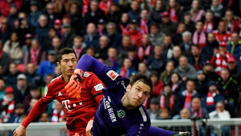 Münchens Robert Lewandowski (l) kämpft mit Hannovers Torwart Michael Esser um den Ball. Foto: Angelika Warmuth