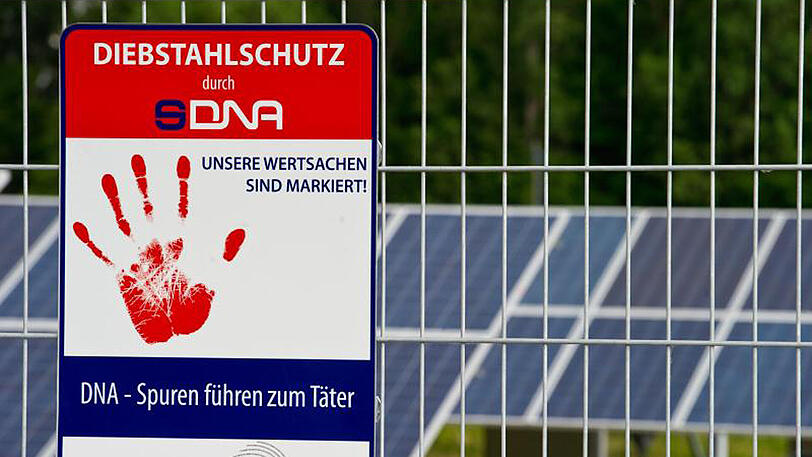 Ein Schild am Solarpark in Senftenberg (Brandenburg) weist auf den Diebstahlschutz der Solarmodule durch eine künstliche Hightech-DNA hin.