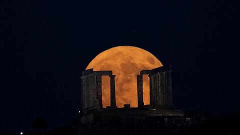 Der Supermond geht hinter dem Poseidon-Tempel am Kap Sounio südlich von Athen auf.